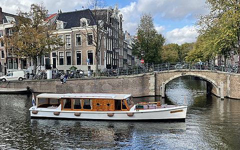 Klassieke salonboot met glazen kap op een Amsterdamse gracht